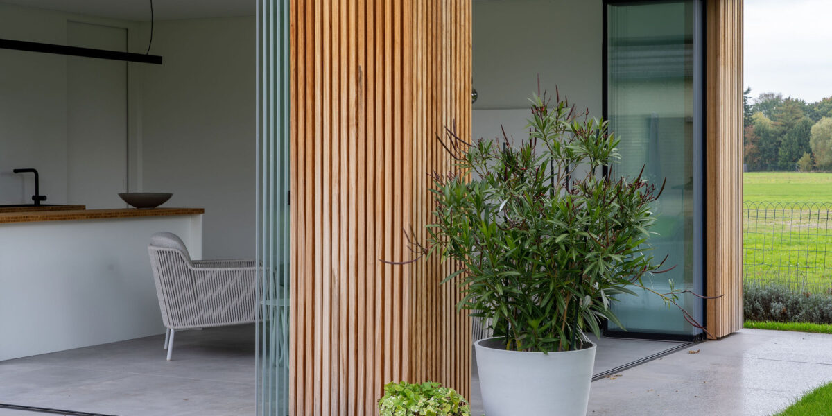 Geopende panelen in een houten buitenkeuken met een draaibare schuifwand
