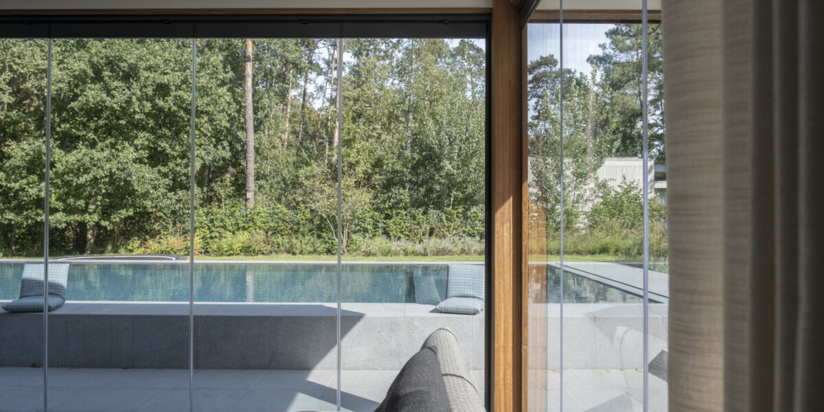 Draaibare schuifwand poolhouse in Keerbergen - met gesloten panelen, zicht op het zwembad